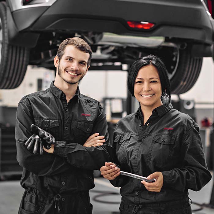 mechanics standing by vehicle on lift