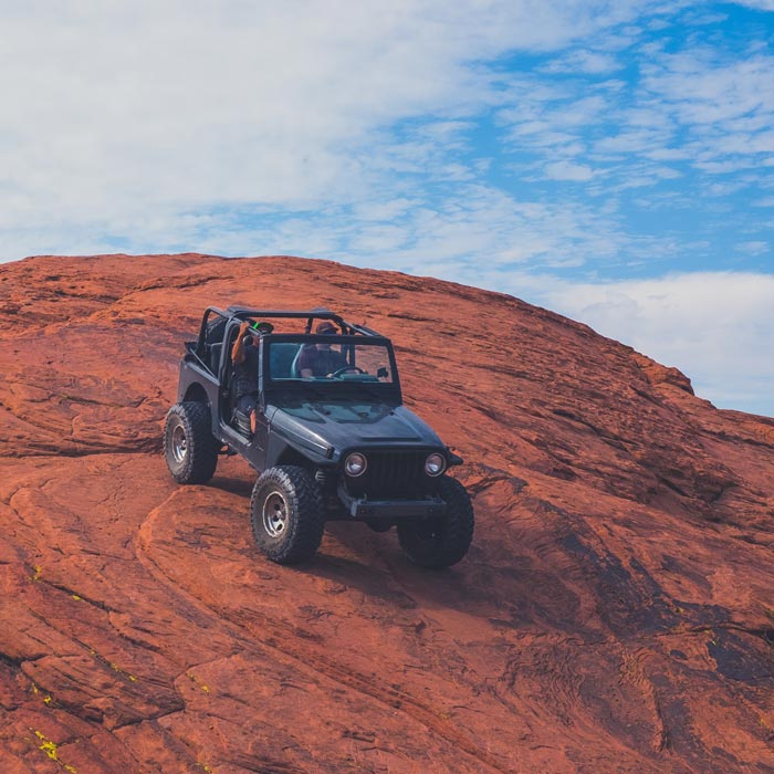 SUV climbing rocky terrain with off-road tires, demonstrating rugged performance in Timonium, MD.